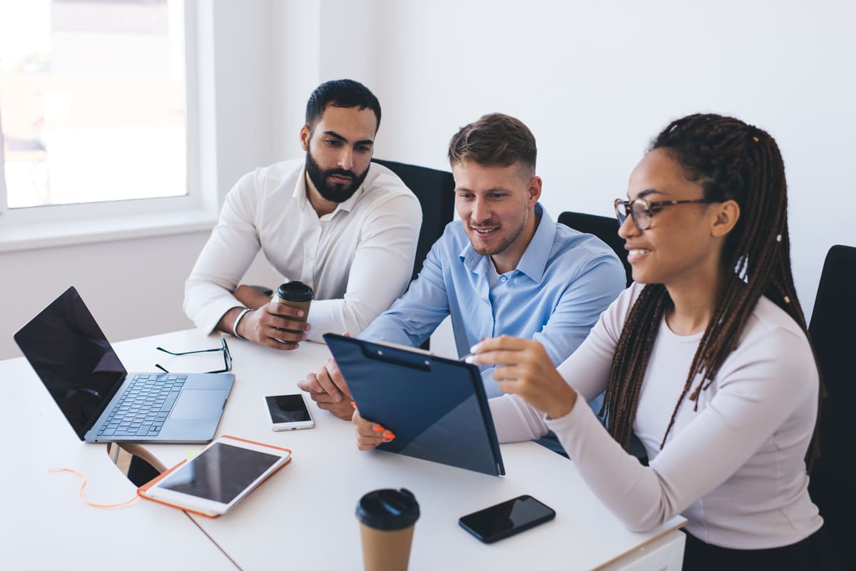 Group of employees discussing paper notes while analyzing report statistics